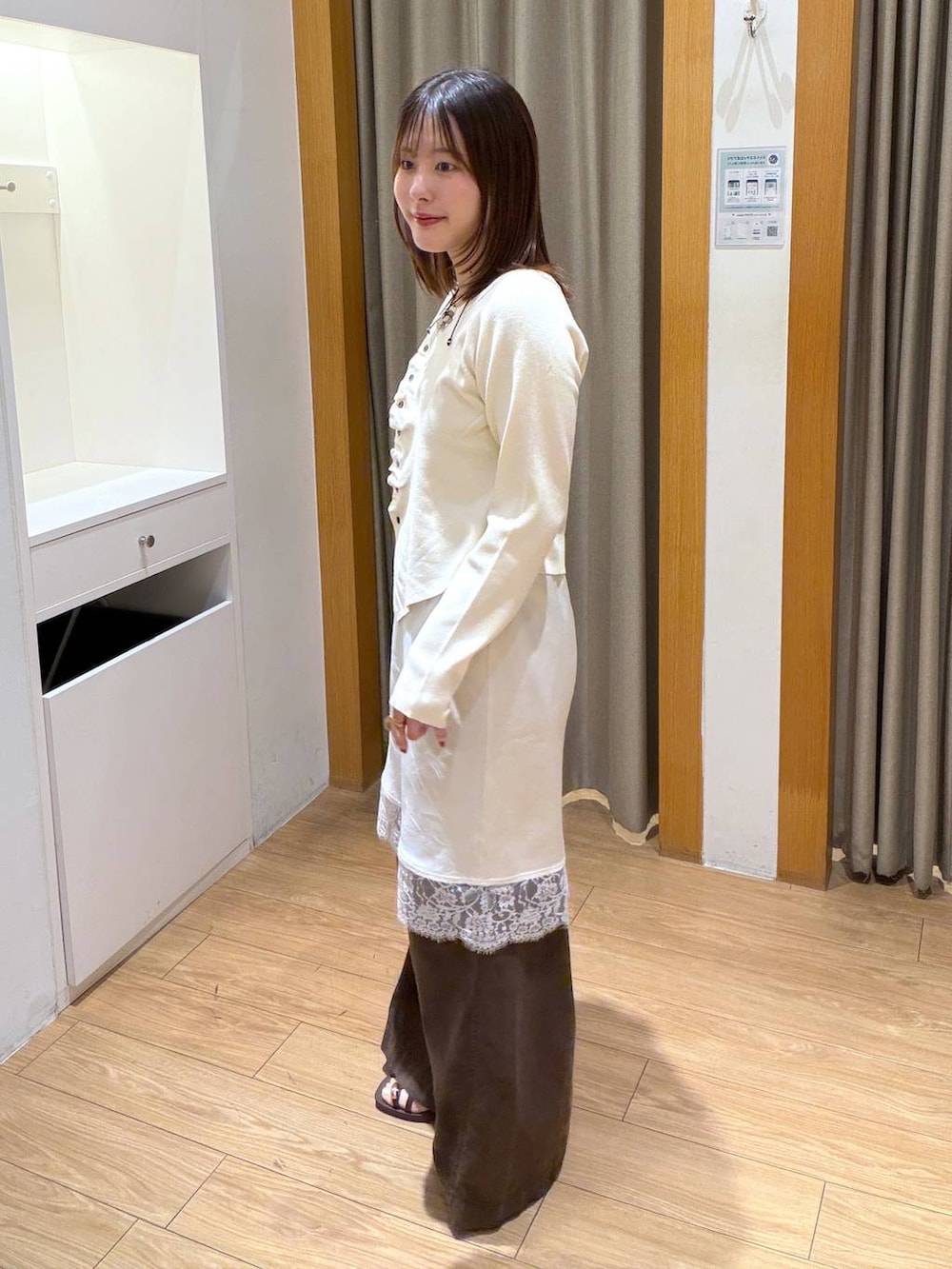 ホワイト系のニット/セーター、ブラウン系のサンダル、ホワイト系のスカートを着用したレディースの秋コーディネートの2枚目の写真
