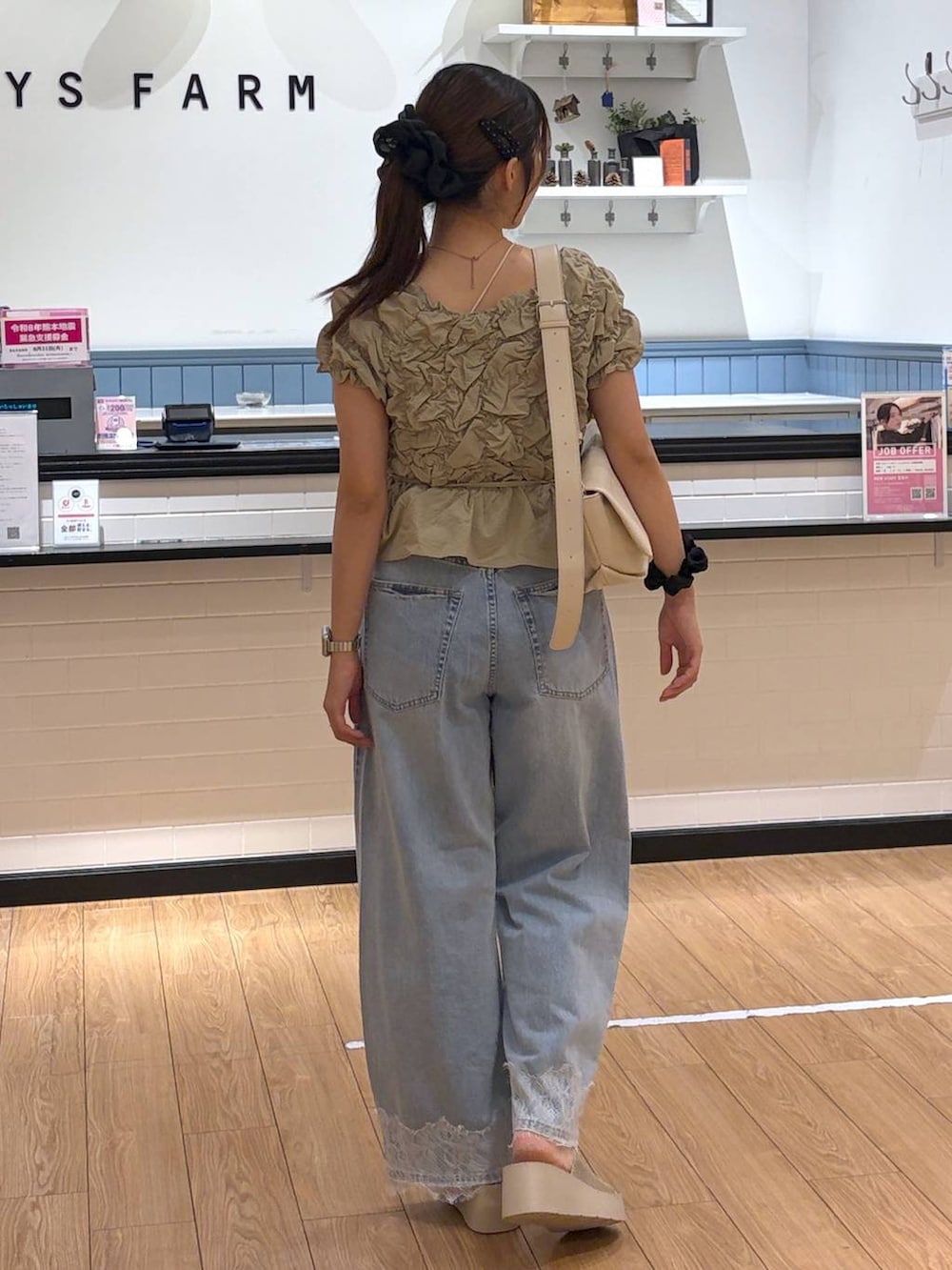 ベージュ系のシャツ/ブラウス、ホワイト系のショルダーバッグ、ブルー系のデニムパンツを着用したレディースの夏コーディネートの3枚目の写真