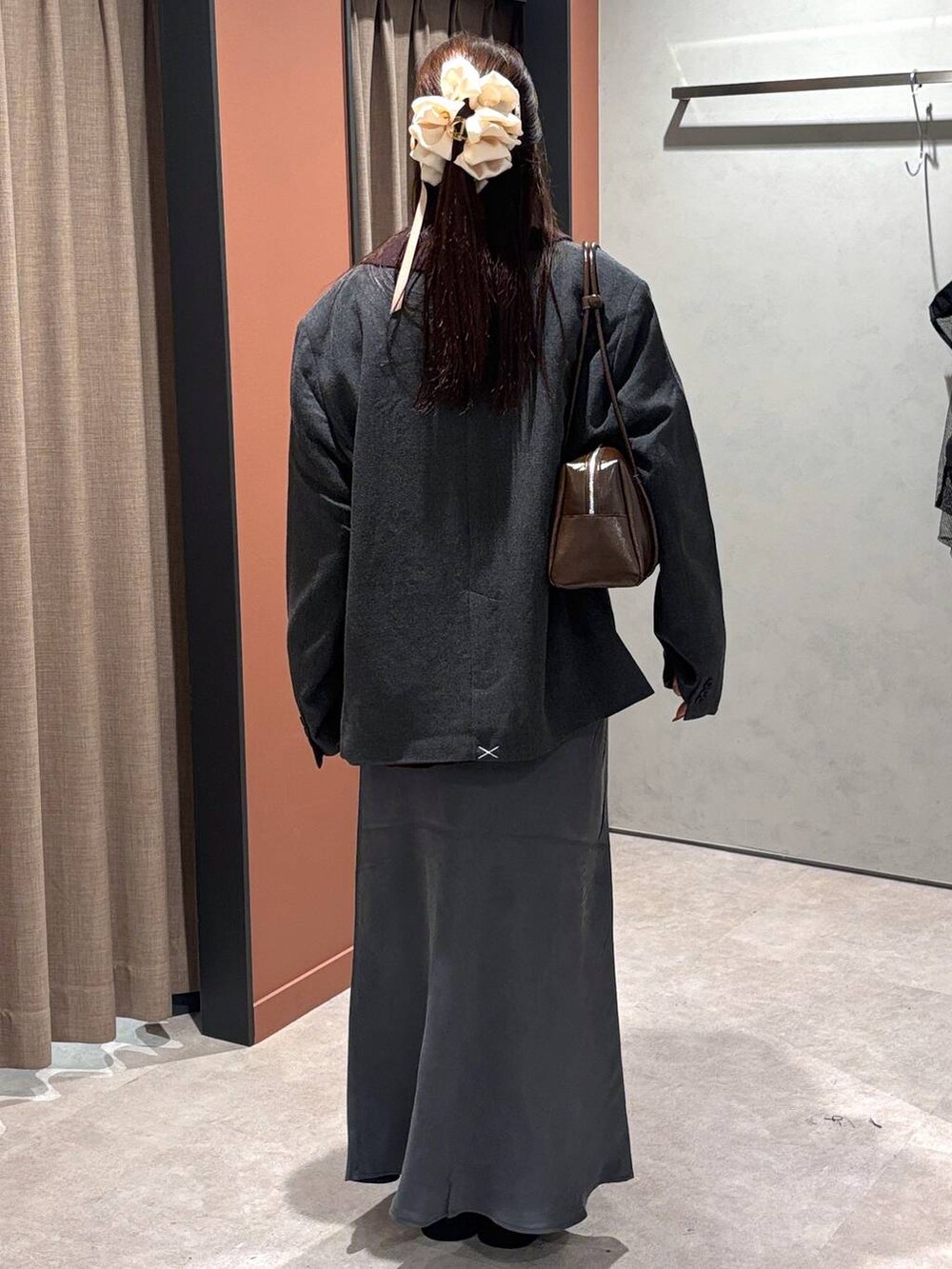 ブラック系のサンダル、グレー系のスカート、ブラウン系のニット/セーターを着用したレディースの秋コーディネートの3枚目の写真