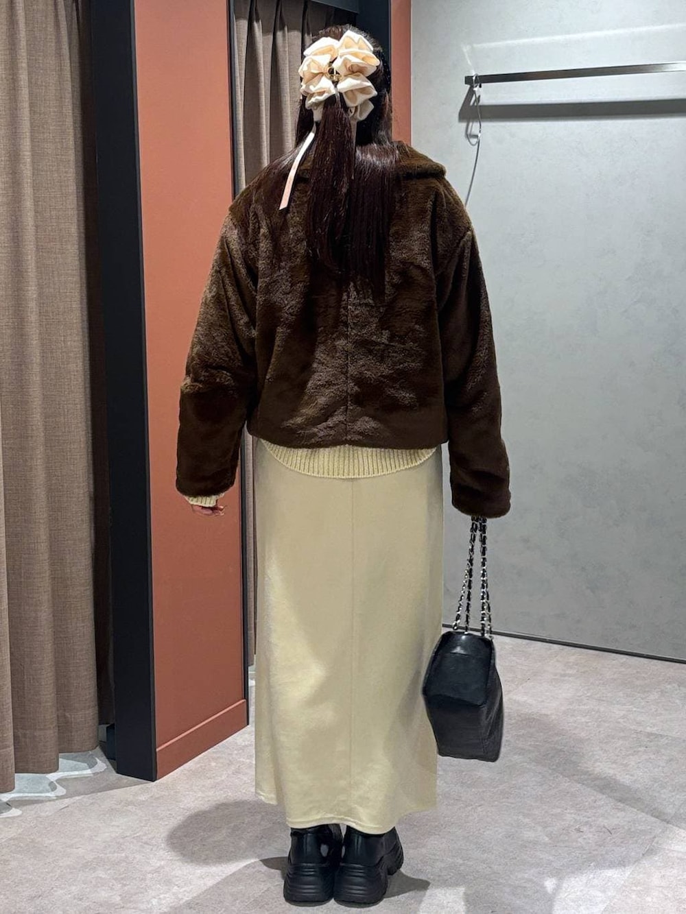 ブラック系のブーツ、ブラウン系のブルゾン、ホワイト系のスカートを着用したレディースの冬コーディネートの3枚目の写真