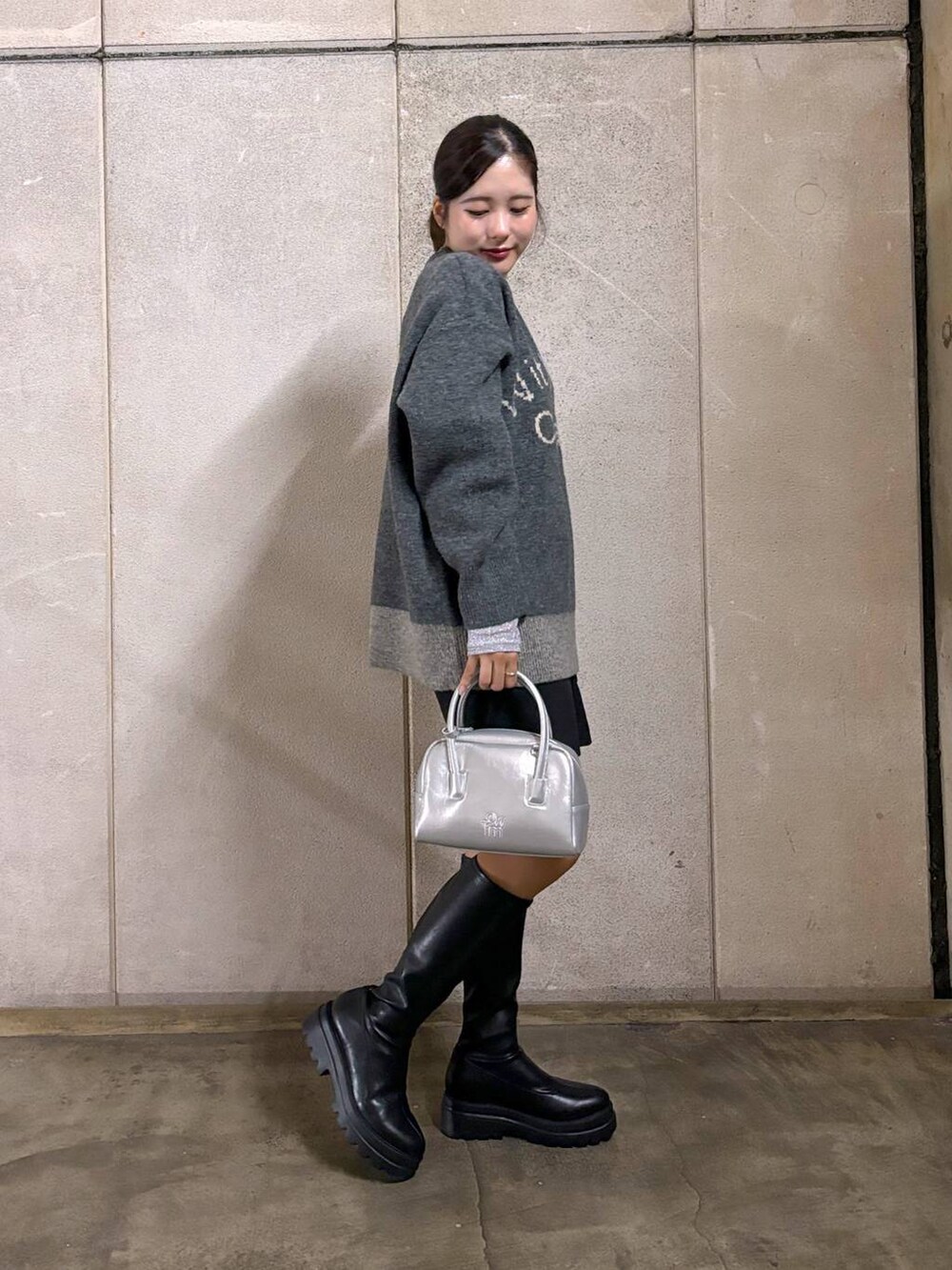 ブラック系のブーツ、グレー系のニット/セーター、ブラック系のその他パンツを着用したレディースの秋コーディネートの4枚目の写真