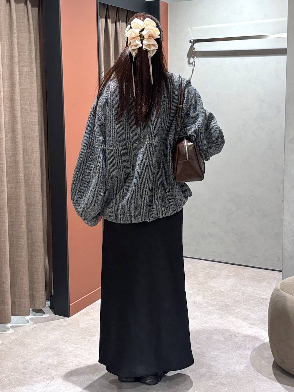 ブラック系のブーツ、ブラック系のスカート、グレー系のブルゾンを着用したレディースの秋コーディネートの3枚目の写真