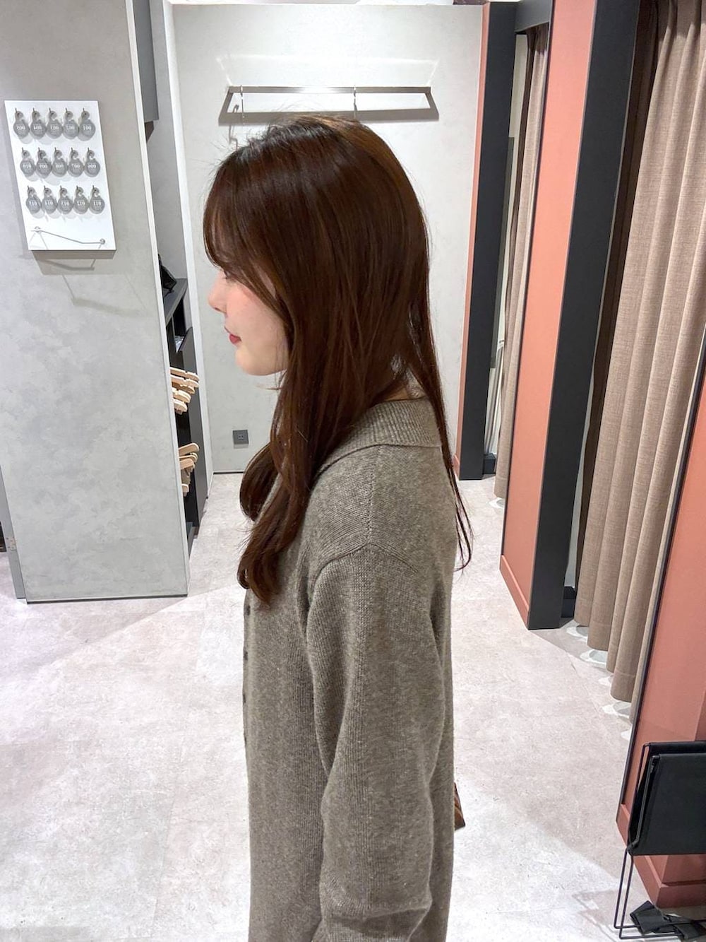 ブラウン系のショルダーバッグ、ブラウン系のワンピース、ホワイト系のTシャツ/カットソーを着用したレディースの冬コーディネートの2枚目の写真