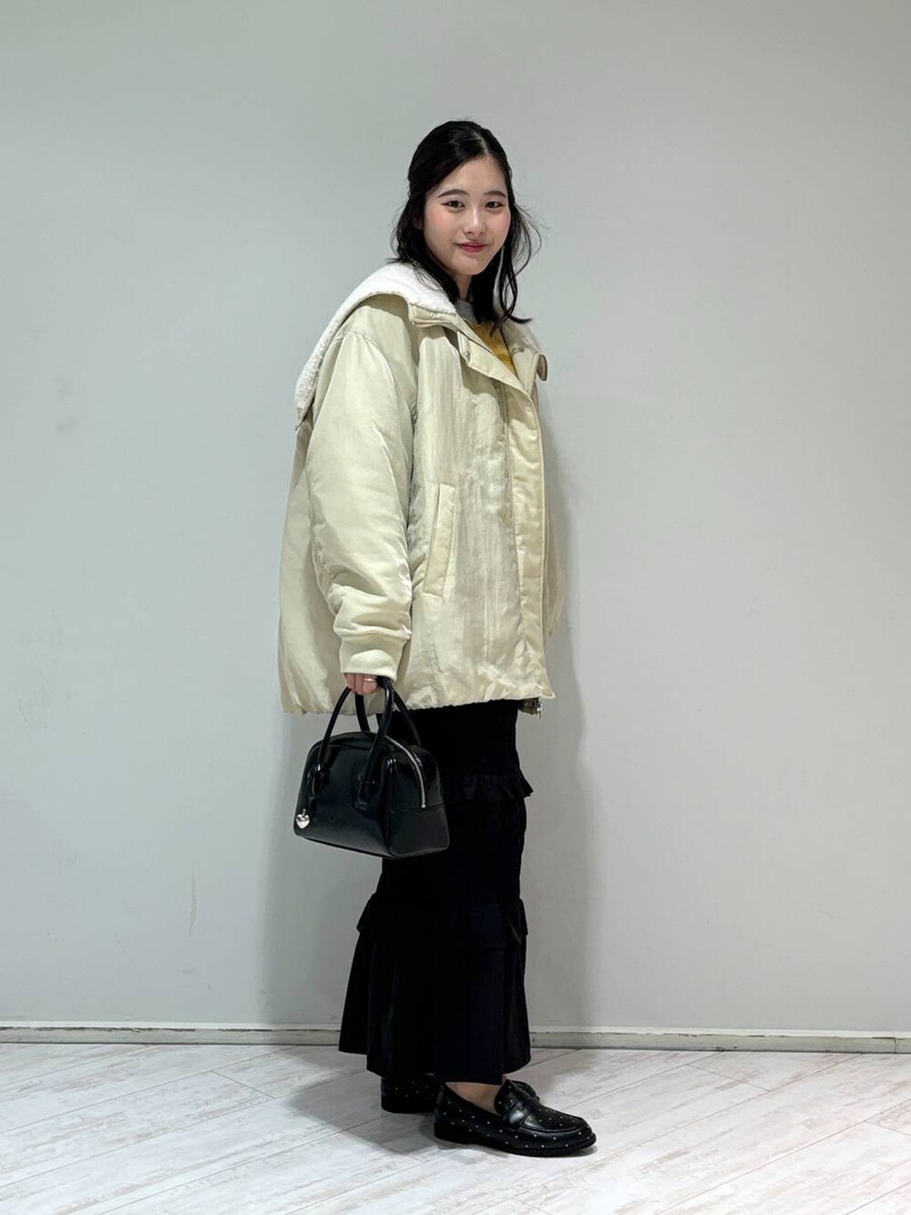 ホワイト系のブルゾン、グレー系のニット/セーター、ブラック系のローファーを着用したレディースの秋コーディネートの2枚目の写真