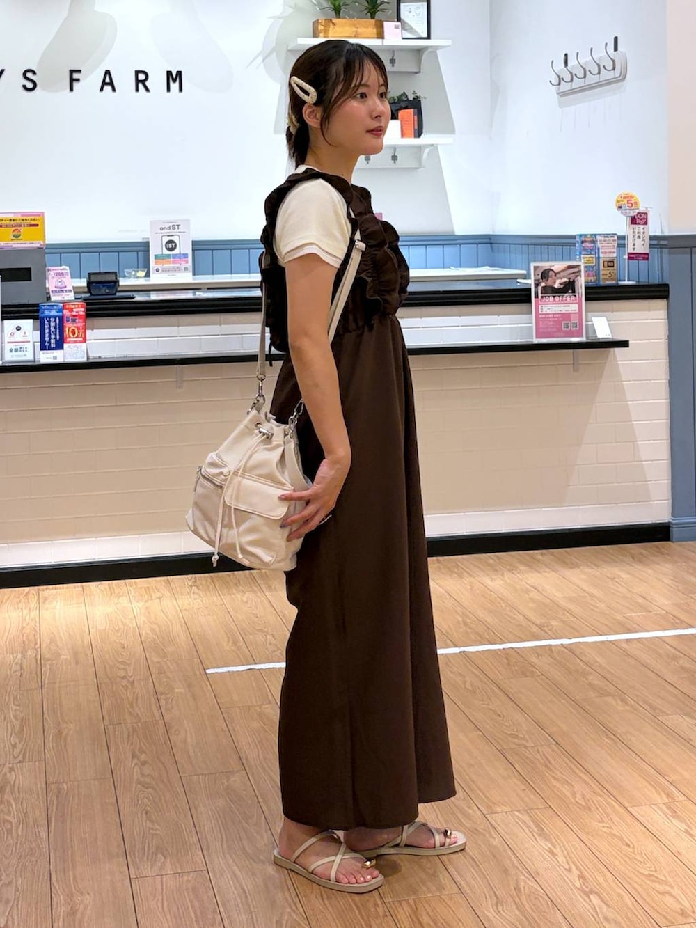 ホワイト系のサンダル、ホワイト系のショルダーバッグ、ホワイト系のTシャツ/カットソーを着用したレディースの夏コーディネートの2枚目の写真