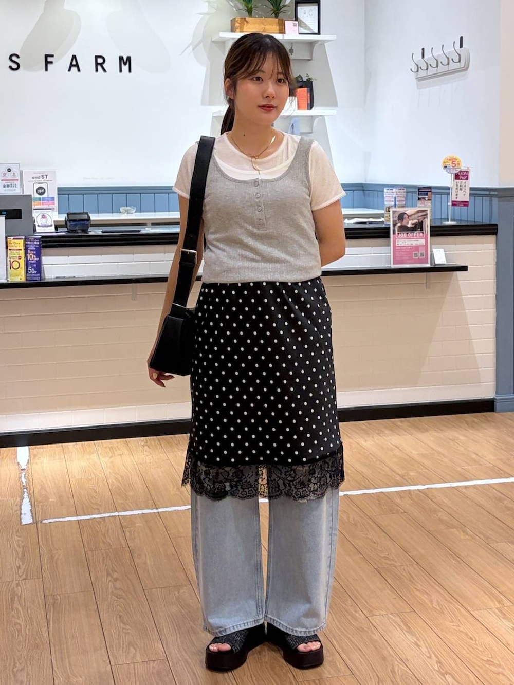 ブルー系のデニムパンツ、ブラック系のサンダル、グレー系のタンクトップを着用したレディースの夏コーディネートの4枚目の写真