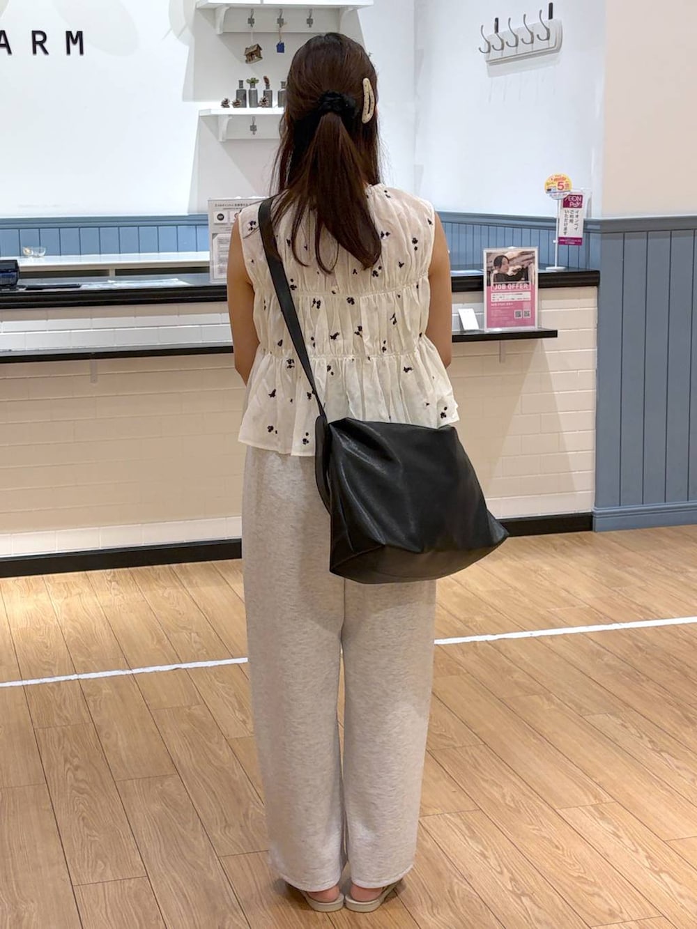 グレー系のスウェットパンツ、ホワイト系のサンダル、ブラック系のショルダーバッグを着用したレディースの夏コーディネートの3枚目の写真