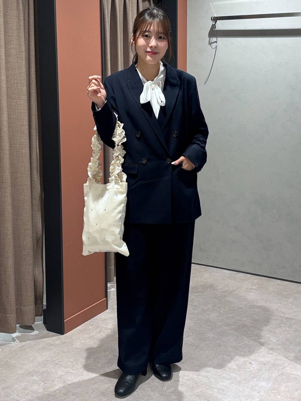 ブラック系のブーツ、ブルー系のテーラードジャケット、ブルー系のスラックスを着用したレディースの冬コーディネートの4枚目の写真