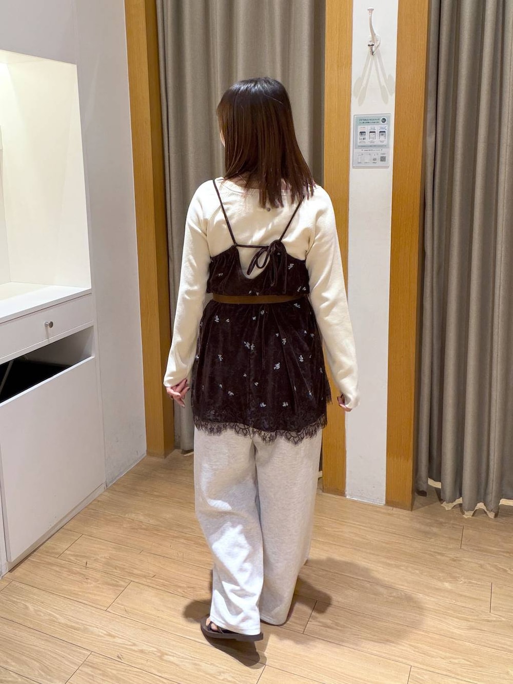 ホワイト系のニット/セーター、ブラウン系のワンピース、グレー系のスウェットパンツを着用したレディースの秋コーディネートの3枚目の写真