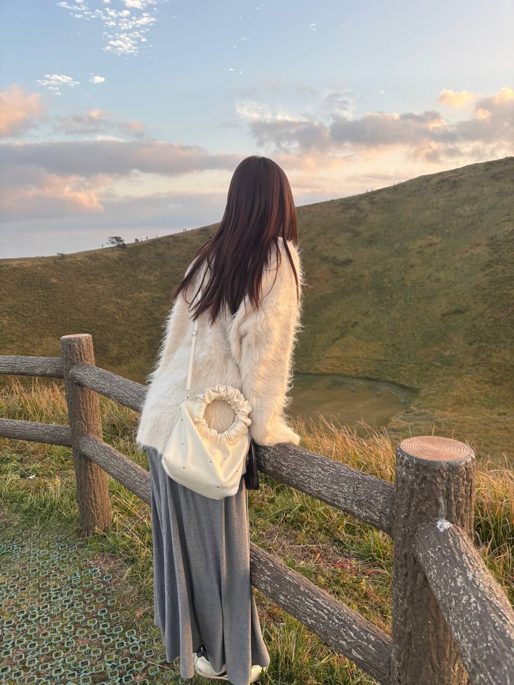 グレー系のスカート、ブラウン系のニット/セーター、ホワイト系のカーディガン/ボレロを着用したレディースの秋コーディネートの4枚目の写真