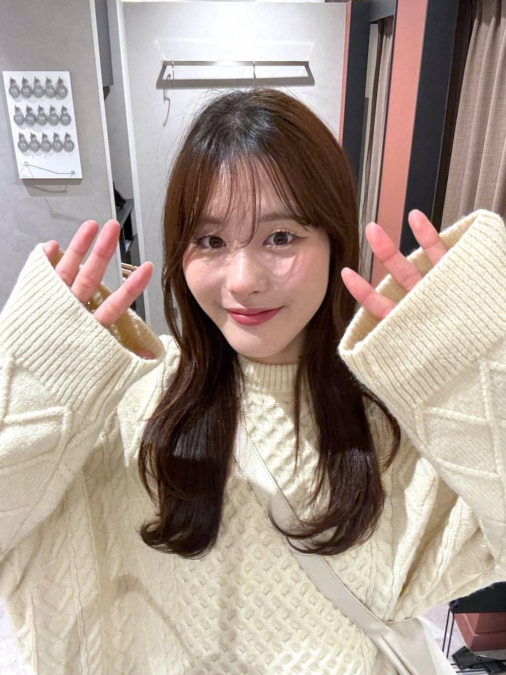 ホワイト系のショルダーバッグ、ホワイト系のニット/セーターを着用したレディースの冬コーディネートの3枚目の写真