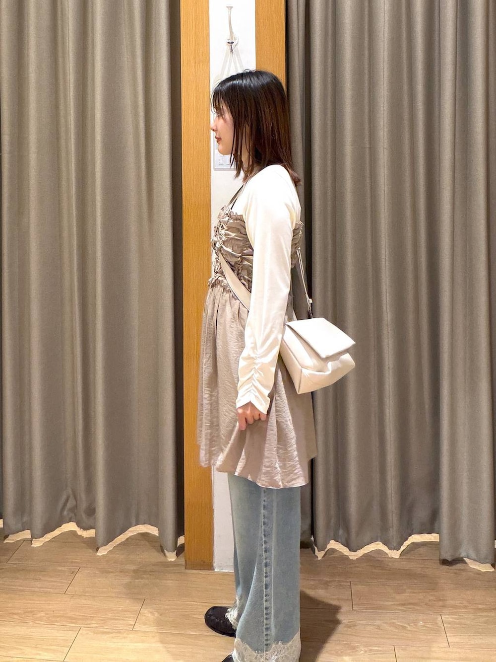 ホワイト系のショルダーバッグ、ブラウン系のローファー、ベージュ系のTシャツ/カットソーを着用したレディースの秋コーディネートの2枚目の写真