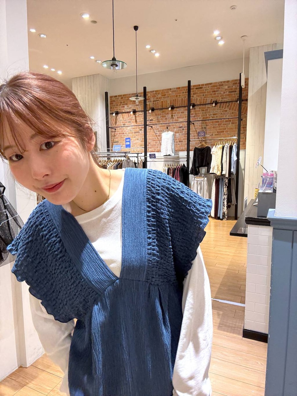 ブルー系のサロペット/オーバーオール、ホワイト系のTシャツ/カットソー、ブラック系のサンダルを着用したレディースの春コーディネートの4枚目の写真