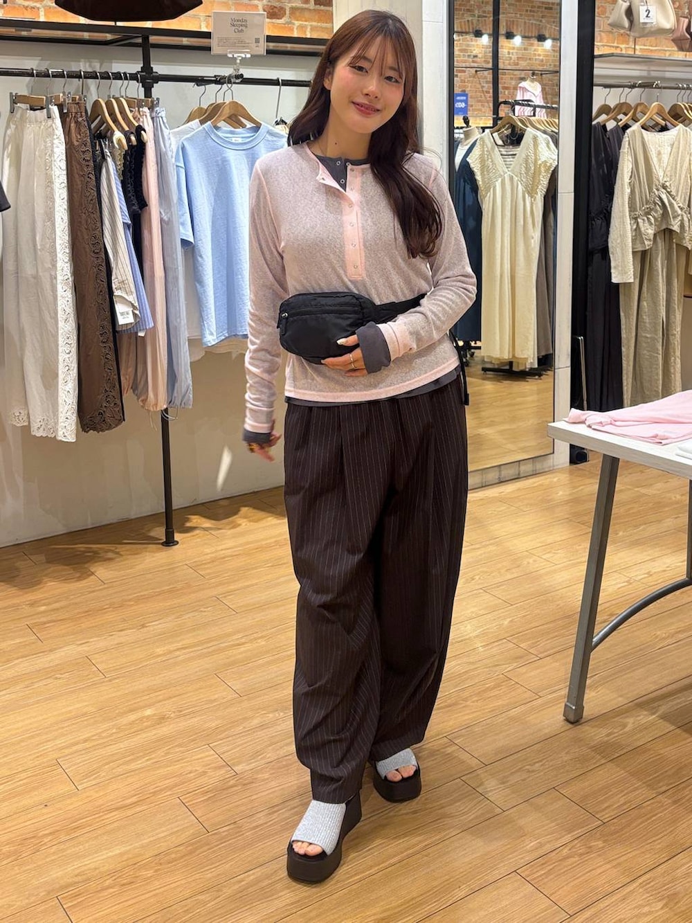 ブラウン系のその他パンツ、ブラック系のボディバッグ/ウエストポーチ、シルバー系のサンダルを着用したレディースの春コーディネートの3枚目の写真