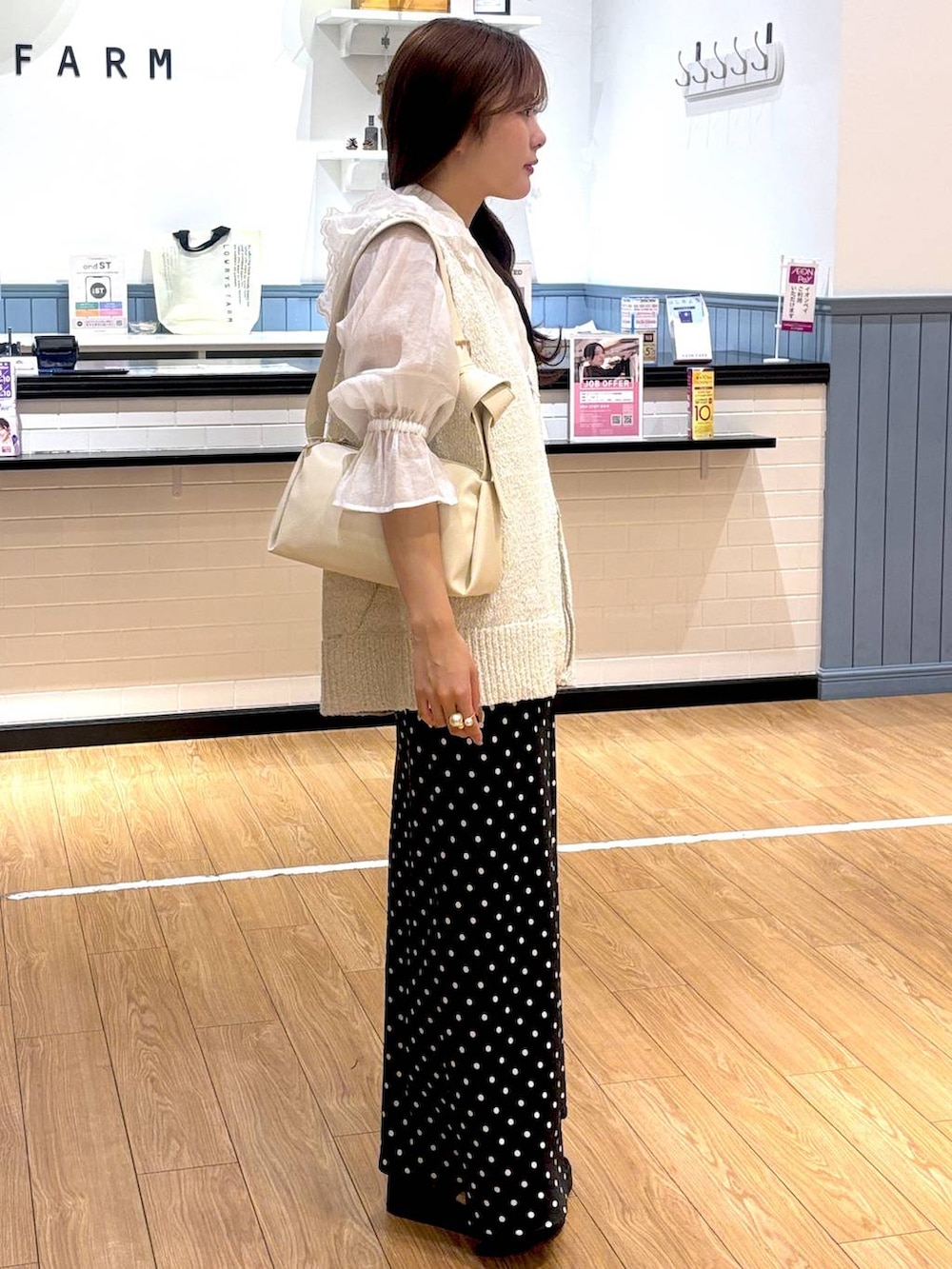 ブラック系のスカート、ホワイト系のシャツ/ブラウス、ブラック系のサンダルを着用したレディースの春コーディネートの2枚目の写真