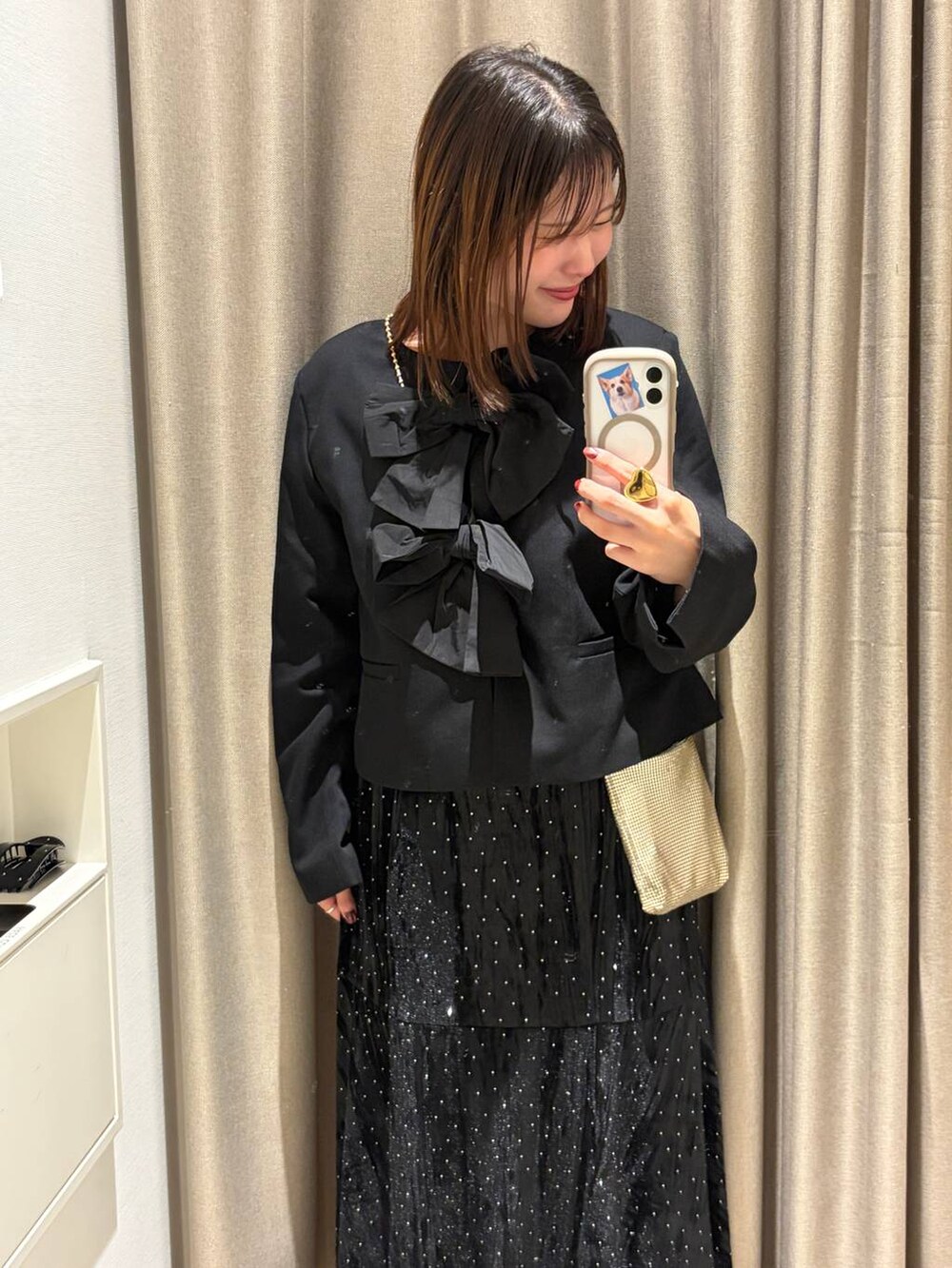 ゴールド系のショルダーバッグ、ブラック系のノーカラージャケット、ホワイト系のバレエシューズを着用したレディースの夏コーディネートの2枚目の写真