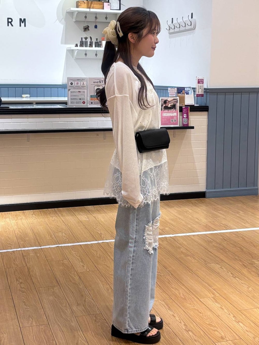 ホワイト系のTシャツ/カットソー、ブルー系のデニムパンツ、ブラック系のサンダルを着用したレディースの春コーディネートの2枚目の写真