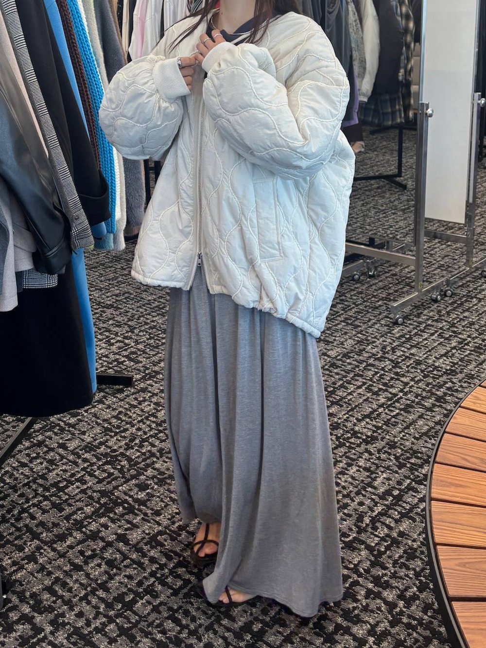 ブラウン系のサンダル、グレー系のスカート、ホワイト系のブルゾンを着用したレディースの秋コーディネートの4枚目の写真