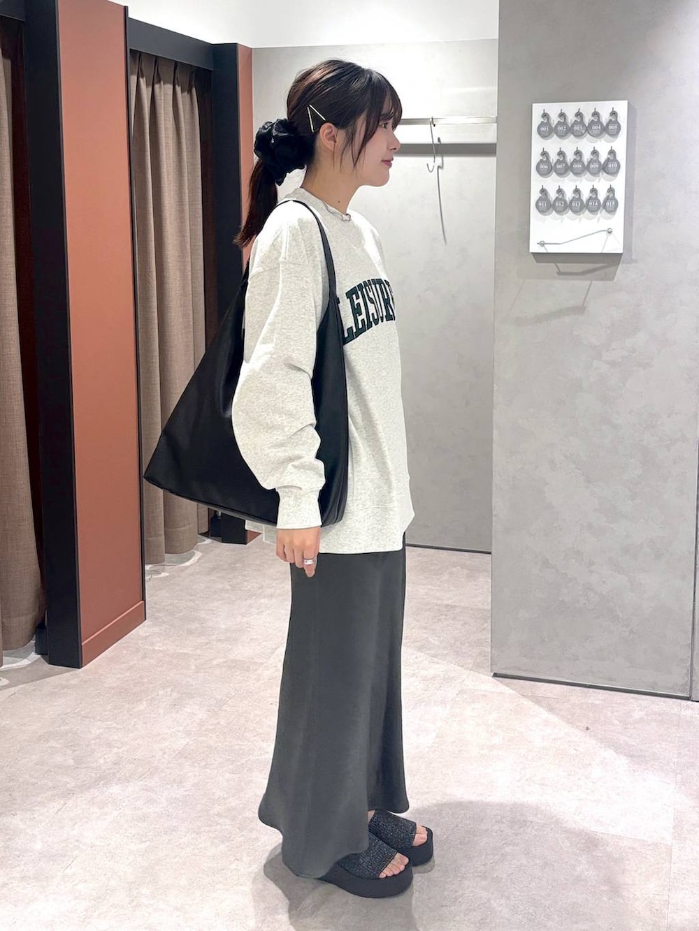 ブラック系のショルダーバッグ、グレー系のスウェット、ブラック系のサンダルを着用したレディースの春コーディネートの2枚目の写真