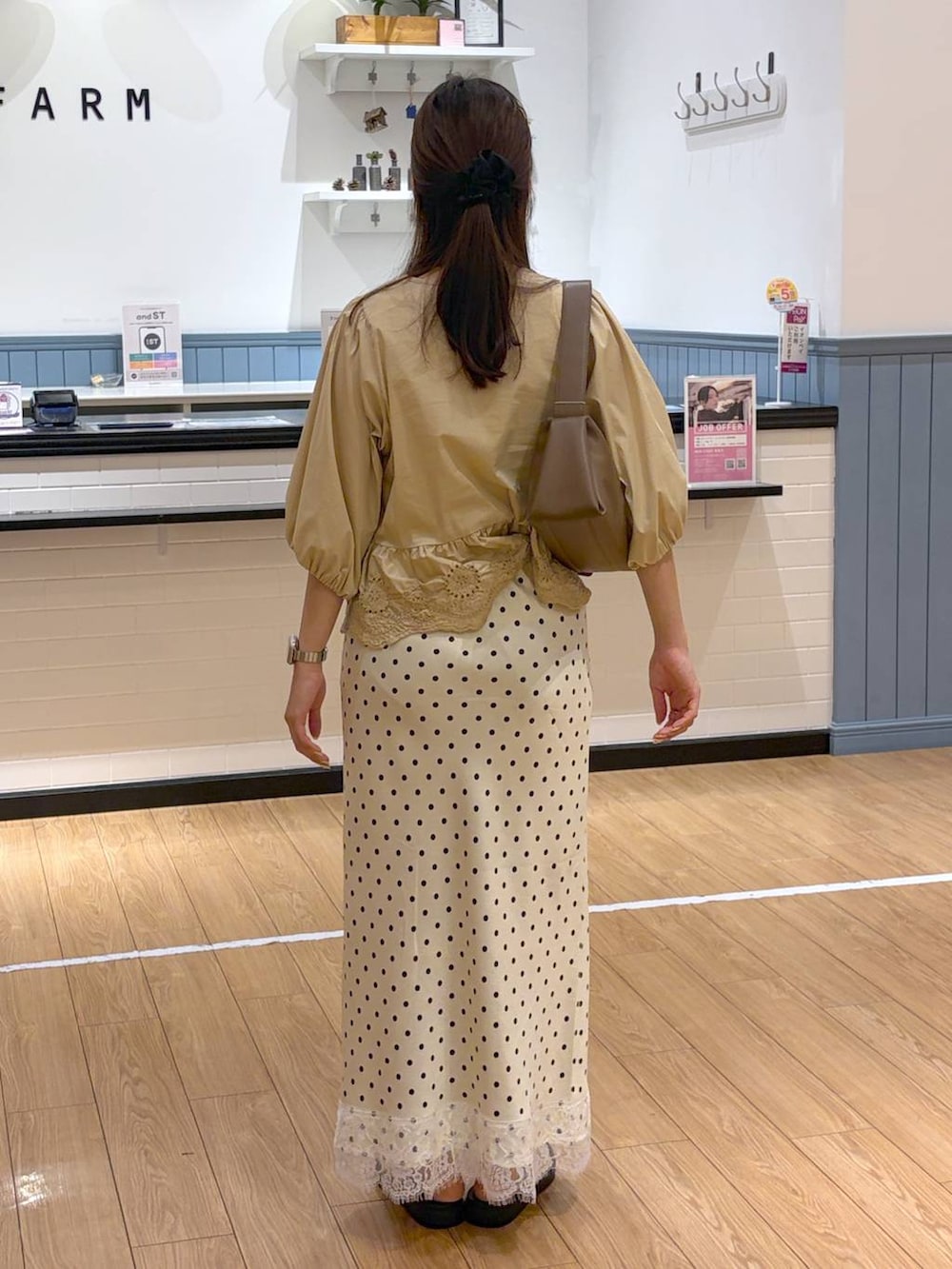 ホワイト系のサンダル、ベージュ系のシャツ/ブラウス、ブラウン系のショルダーバッグを着用したレディースの夏コーディネートの3枚目の写真