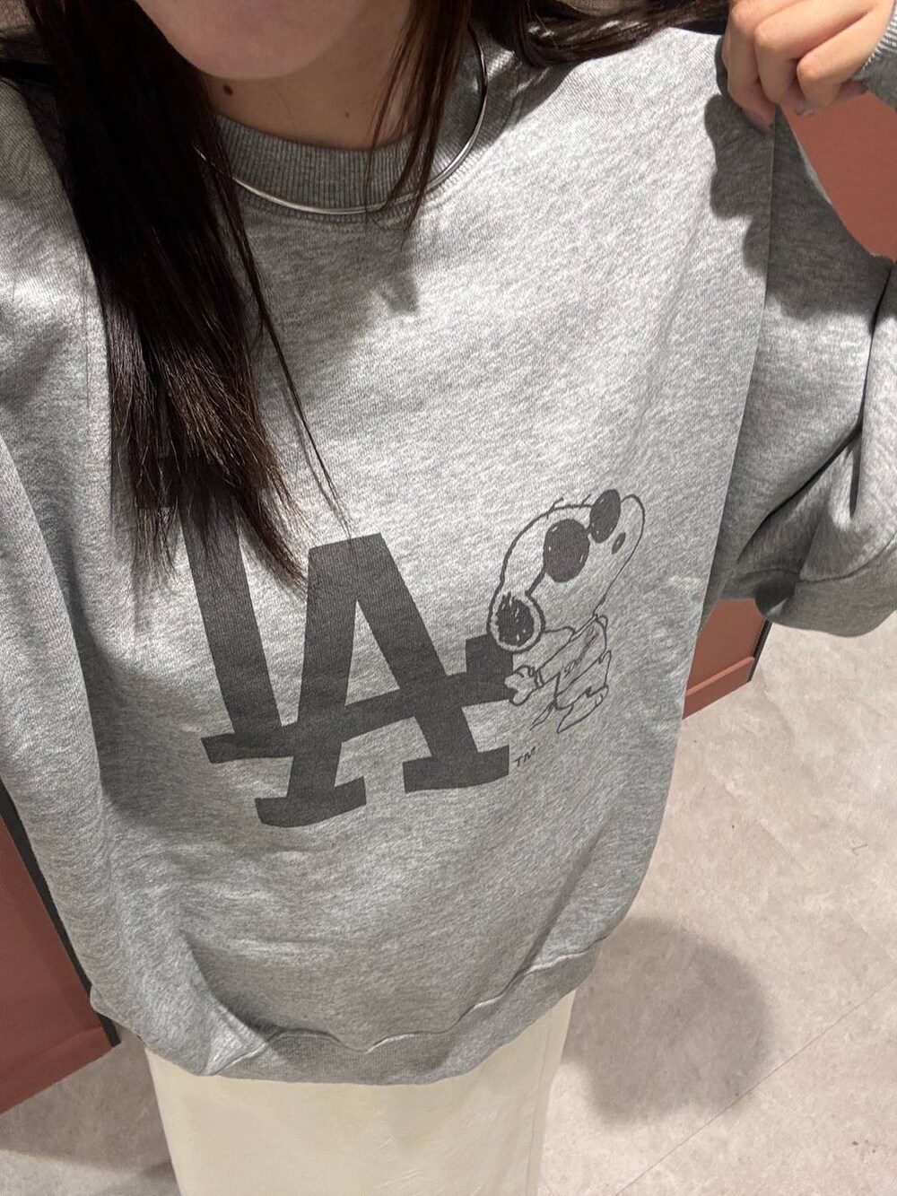 ホワイト系のスカート、シルバー系のスウェット、グレー系のチョーカーを着用したレディースの夏コーディネートの3枚目の写真