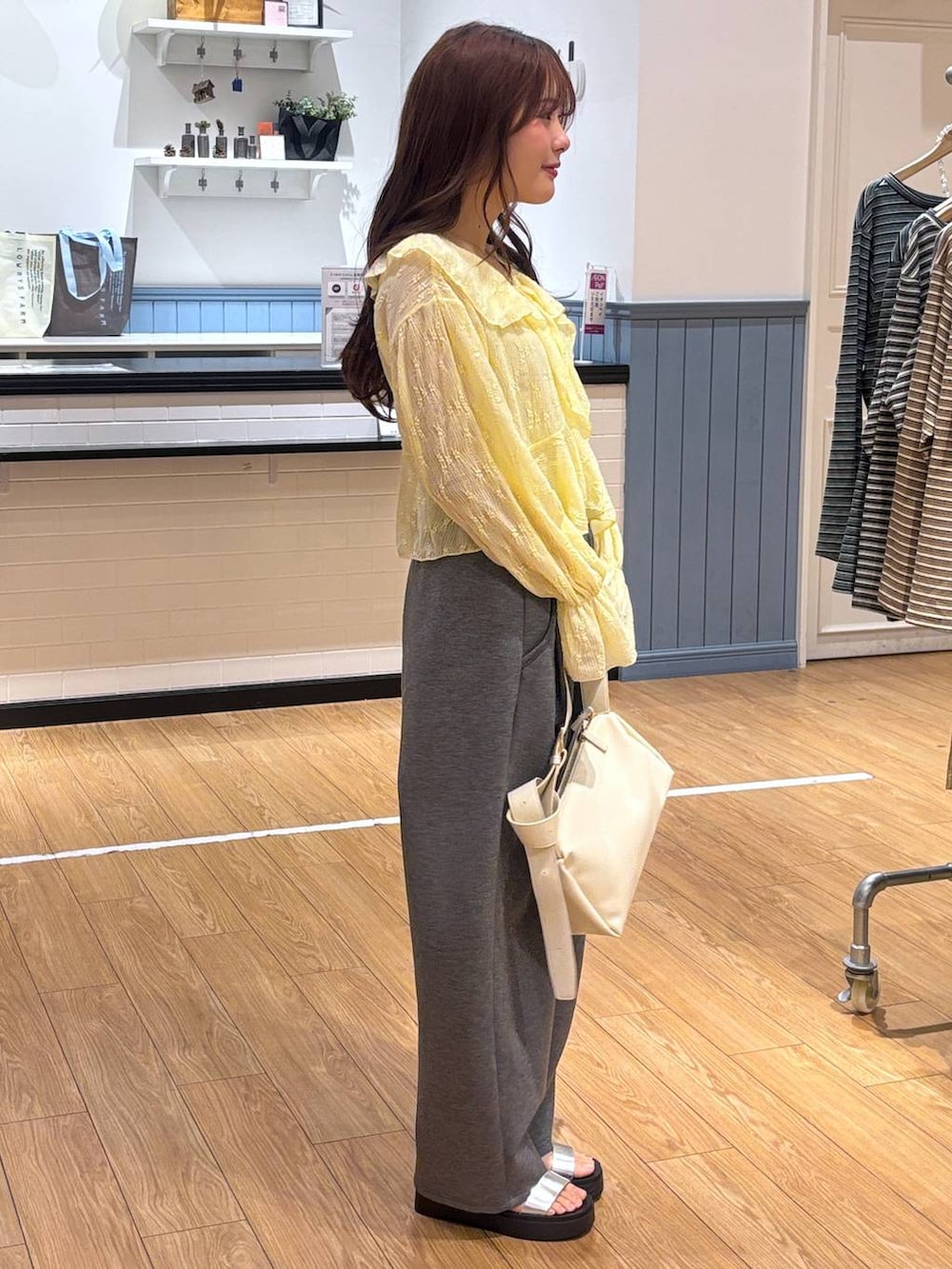 グレー系のスウェットパンツ、シルバー系のサンダル、ホワイト系のショルダーバッグを着用したレディースの春コーディネートの2枚目の写真