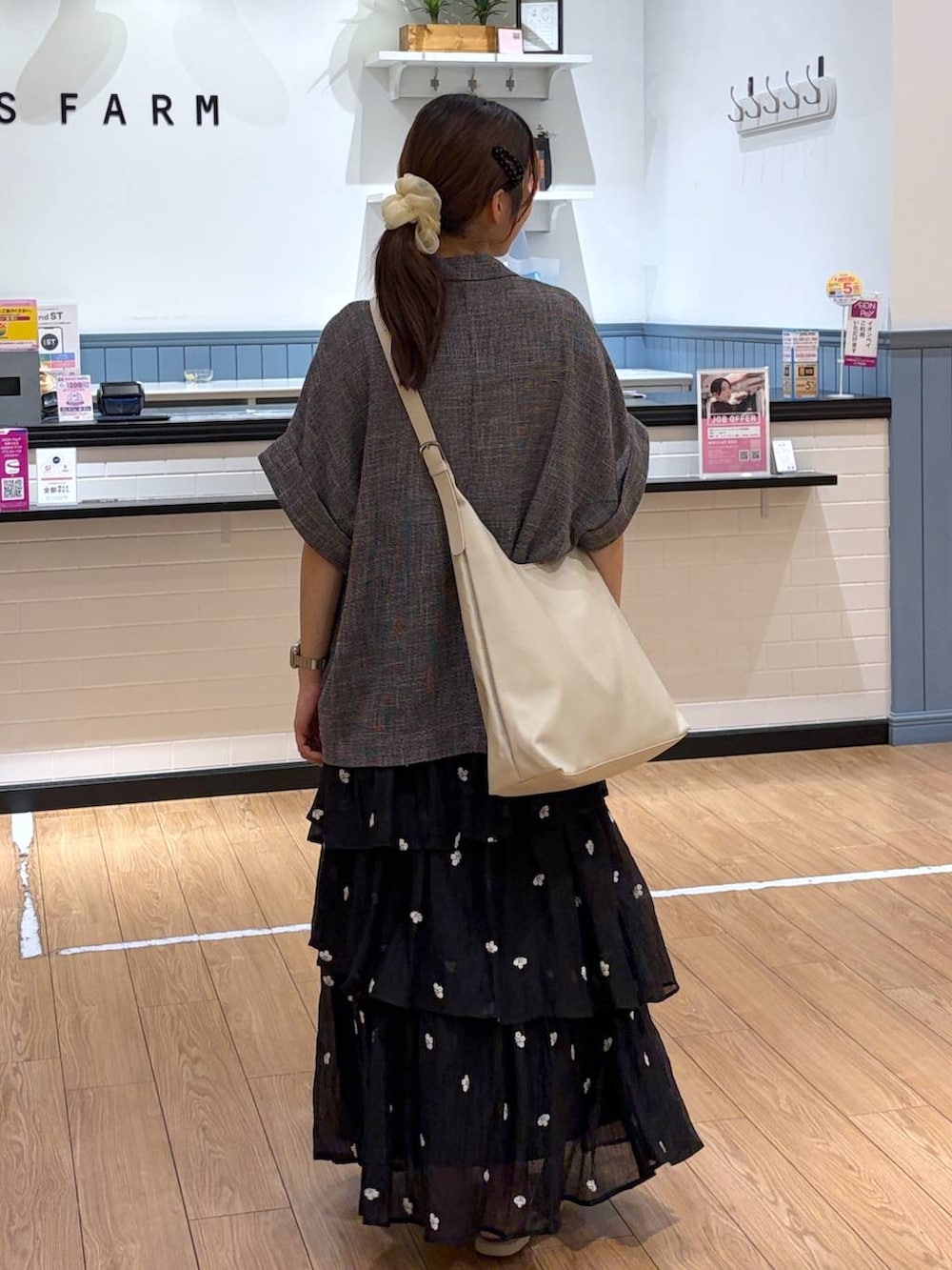 ホワイト系のショルダーバッグ、ホワイト系のサンダル、ブラック系のスカートを着用したレディースの夏コーディネートの3枚目の写真