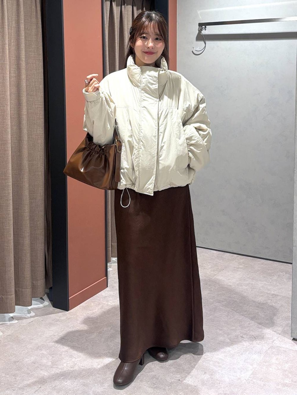 ホワイト系のその他アウター、ブラウン系のスカート、ブラウン系のショルダーバッグを着用したレディースの冬コーディネートの4枚目の写真