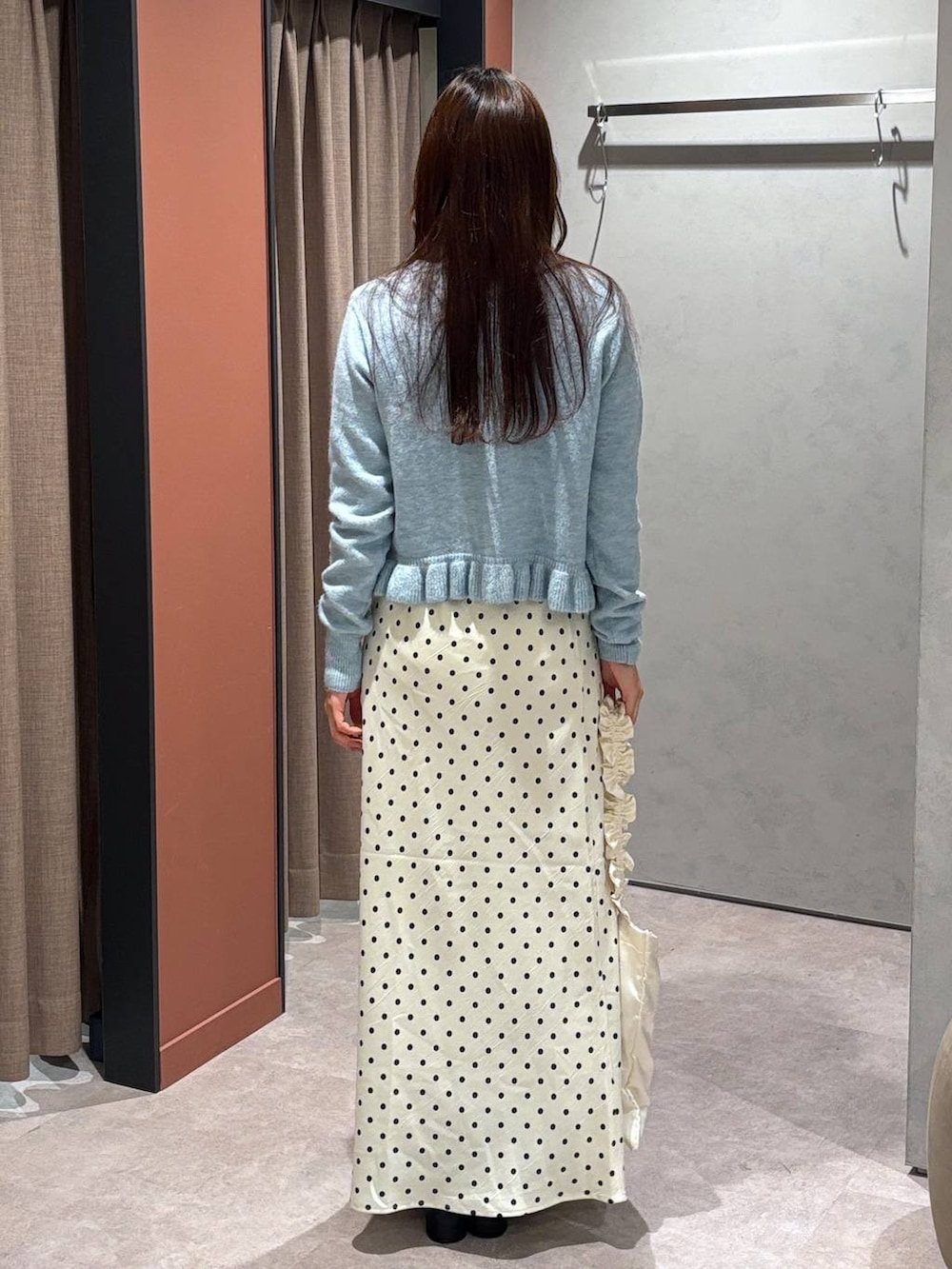 ホワイト系のスカート、ブラック系のブーツ、ブルー系のニット/セーターを着用したレディースの冬コーディネートの3枚目の写真