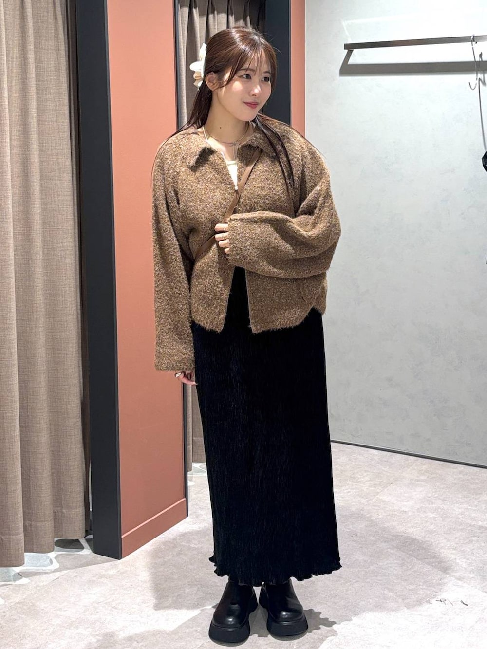 ブラック系のサンダル、ブラック系のスカート、ブラウン系のブルゾンを着用したレディースの秋コーディネートの4枚目の写真