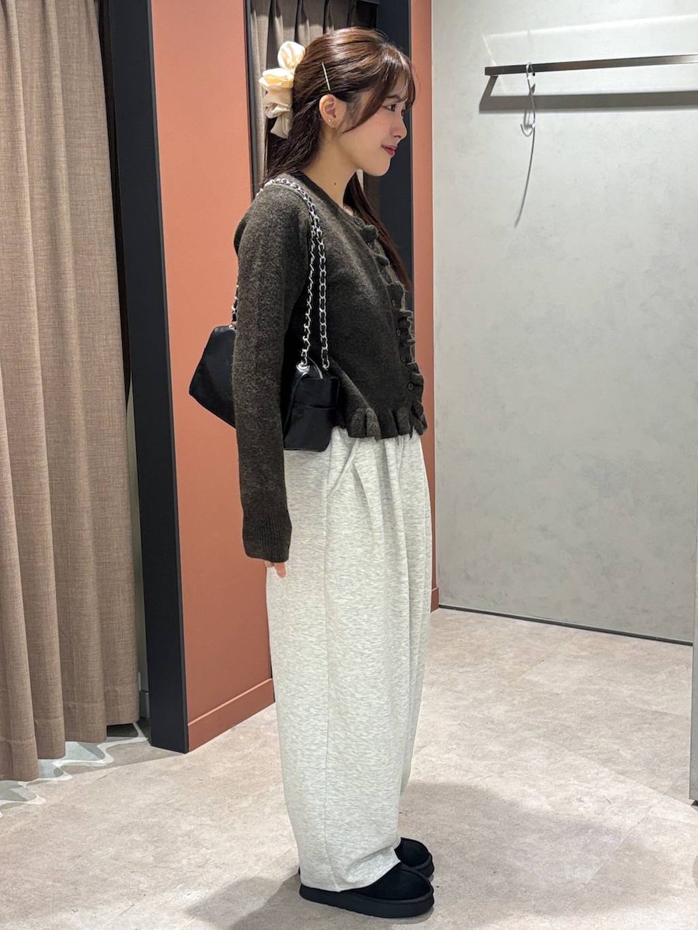 グレー系のスウェットパンツ、ブラック系のその他シューズ、ブラウン系のニット/セーターを着用したレディースの秋コーディネートの2枚目の写真