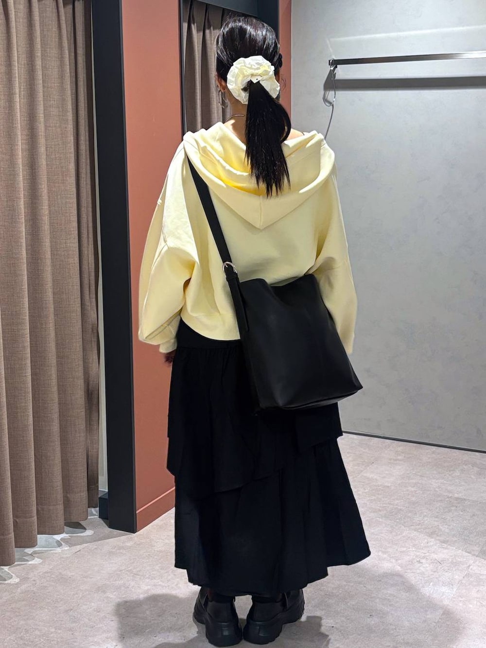 ブラック系のスニーカー、ブラック系のキャミソール、ブラック系のショルダーバッグを着用したレディースの秋コーディネートの3枚目の写真