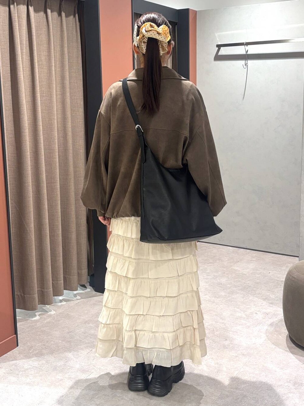 ブラック系のショルダーバッグ、ブラック系のブーツ、ブラウン系のニット/セーターを着用したレディースの秋コーディネートの3枚目の写真