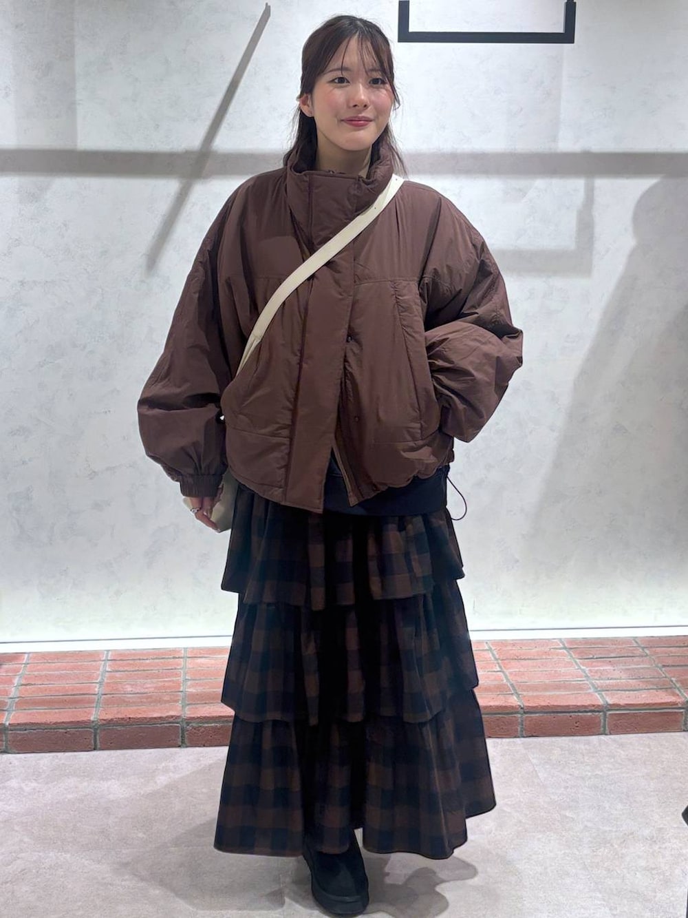 ホワイト系のショルダーバッグ、ブラウン系のその他アウター、ブラウン系のスカートを着用したレディースの秋コーディネートの4枚目の写真