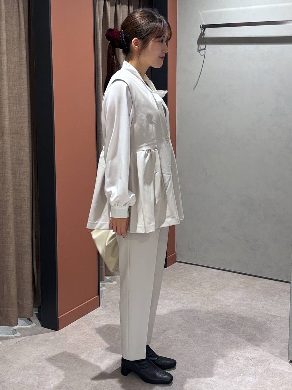 ブラック系のブーツ、ホワイト系のショルダーバッグ、ホワイト系のその他パンツを着用したレディースの冬コーディネートの2枚目の写真