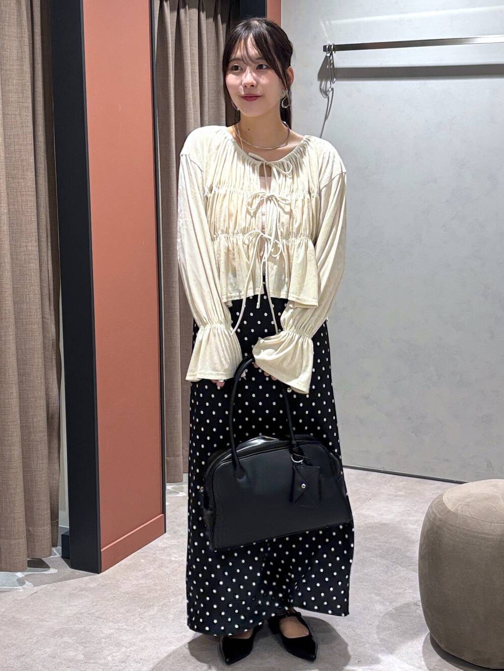 ブラック系のスカート、ブラック系のボストンバッグ、ブラック系のパンプスを着用したレディースの夏コーディネートの4枚目の写真