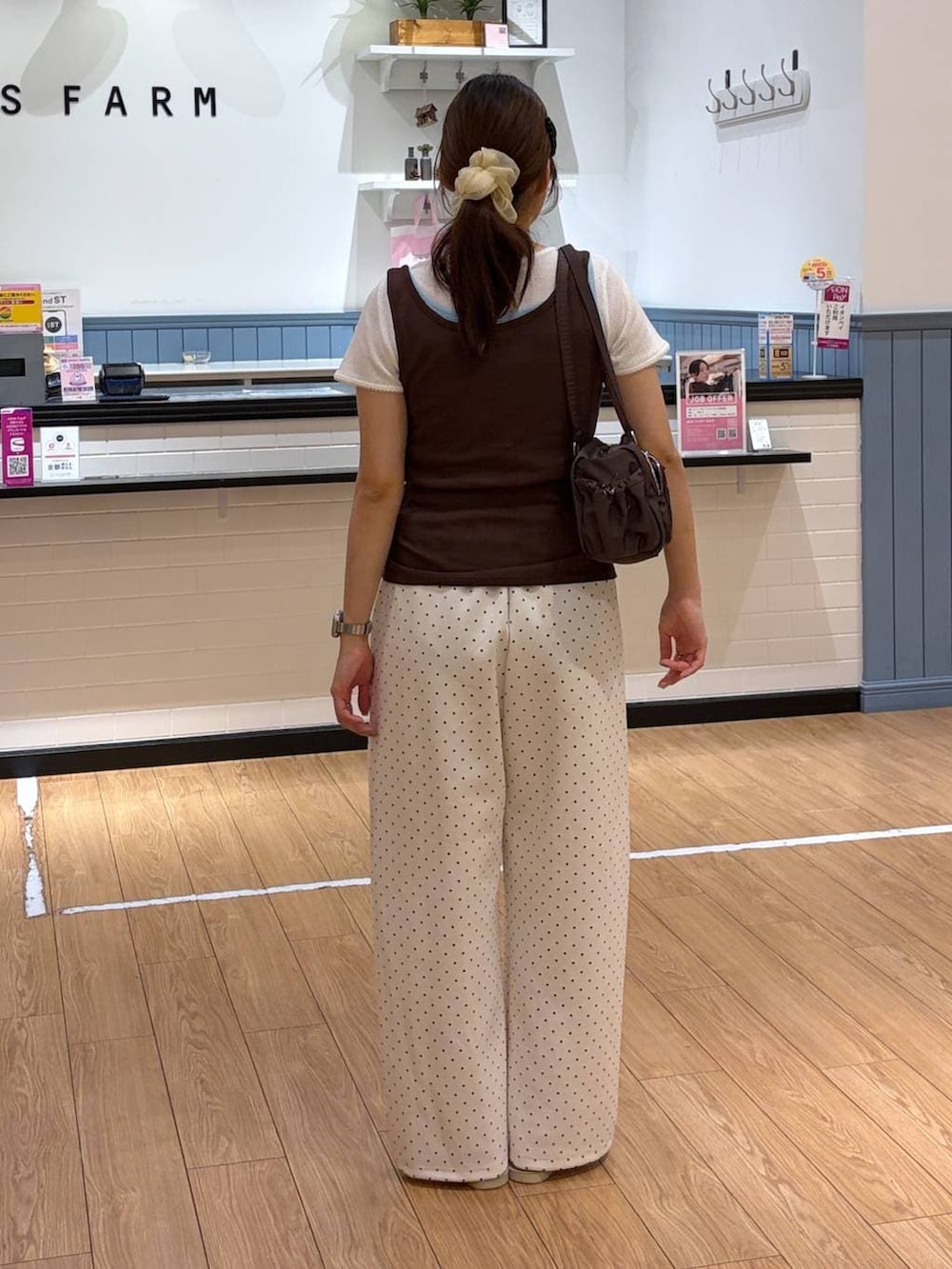 ホワイト系のスウェットパンツ、ホワイト系のサンダル、ブラウン系のタンクトップを着用したレディースの夏コーディネートの2枚目の写真