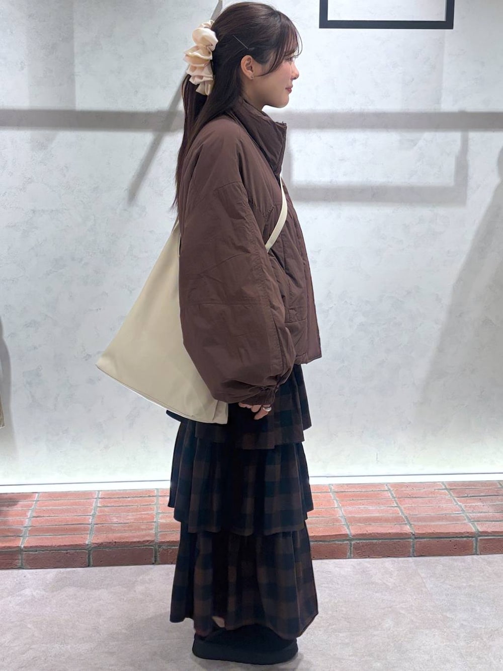 ホワイト系のショルダーバッグ、ブラウン系のその他アウター、ブラウン系のスカートを着用したレディースの秋コーディネートの2枚目の写真