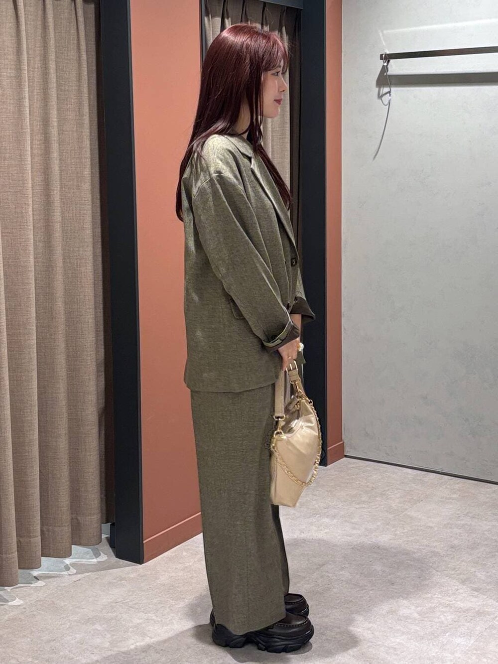 ブラウン系のテーラードジャケット、ブラウン系のデニムパンツ、ベージュ系のショルダーバッグを着用したレディースの冬コーディネートの2枚目の写真