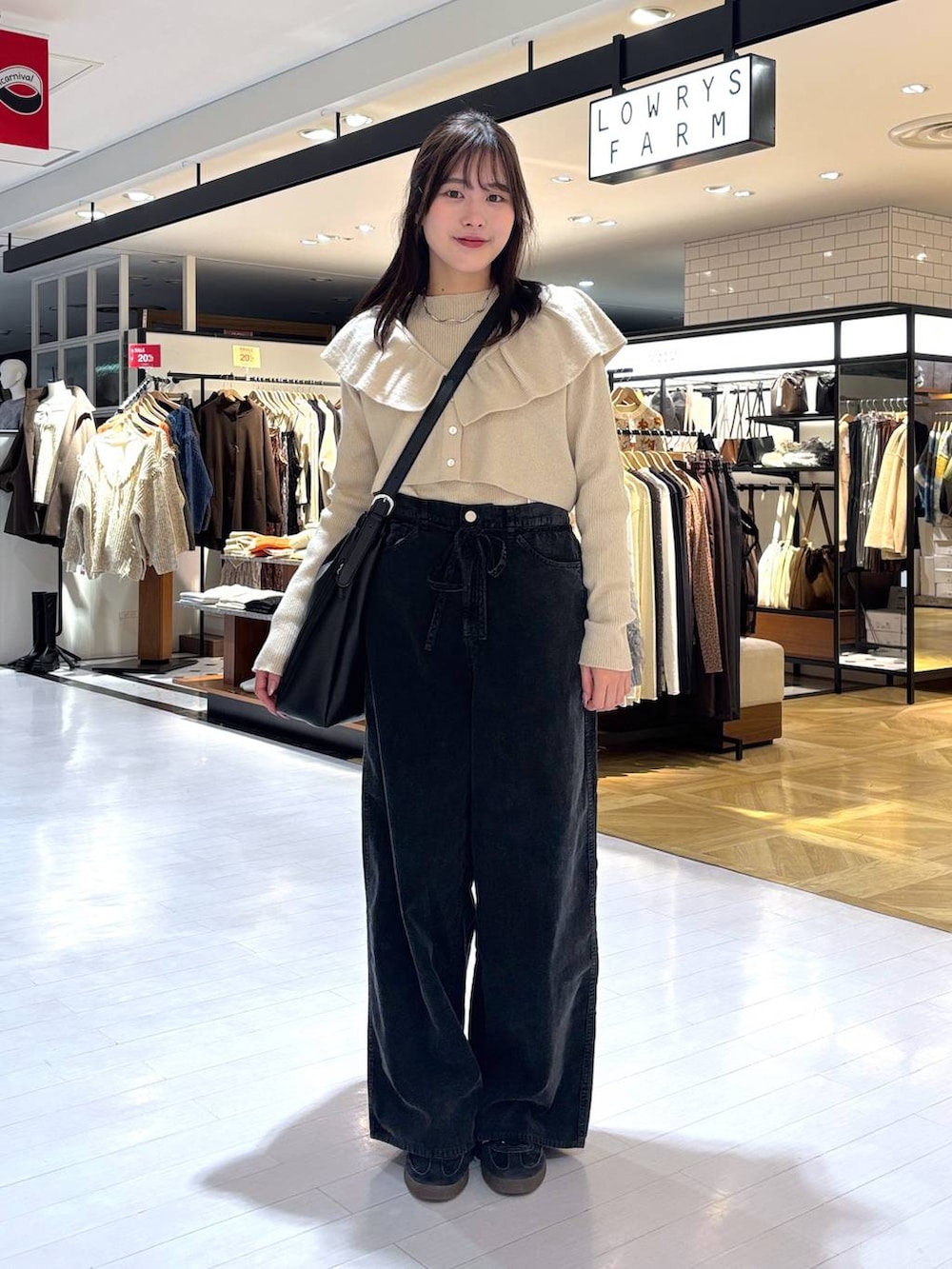 ベージュ系のニット/セーター、グレー系のその他パンツ、ブラック系のトートバッグを着用したレディースの冬コーディネートの2枚目の写真