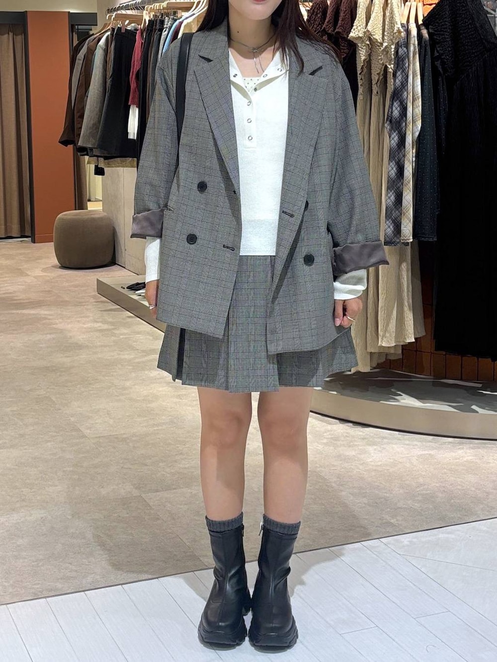 ブラック系のブーツ、グレー系のテーラードジャケット、その他のスカートを着用したレディースの秋コーディネートの4枚目の写真