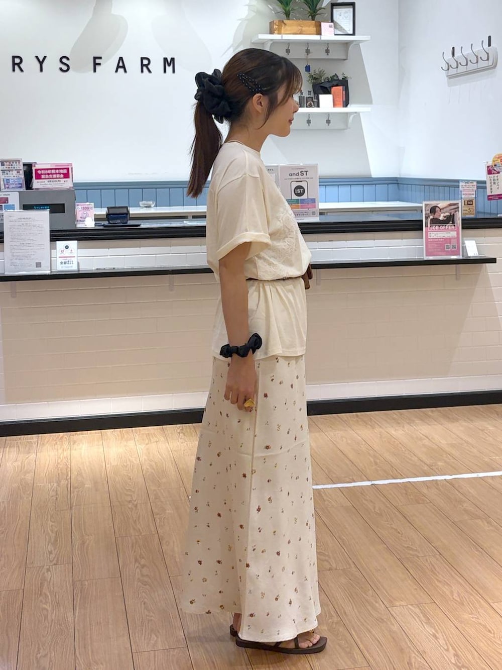 ベージュ系のTシャツ/カットソー、ホワイト系のスカート、ブラウン系のサンダルを着用したレディースの夏コーディネートの2枚目の写真