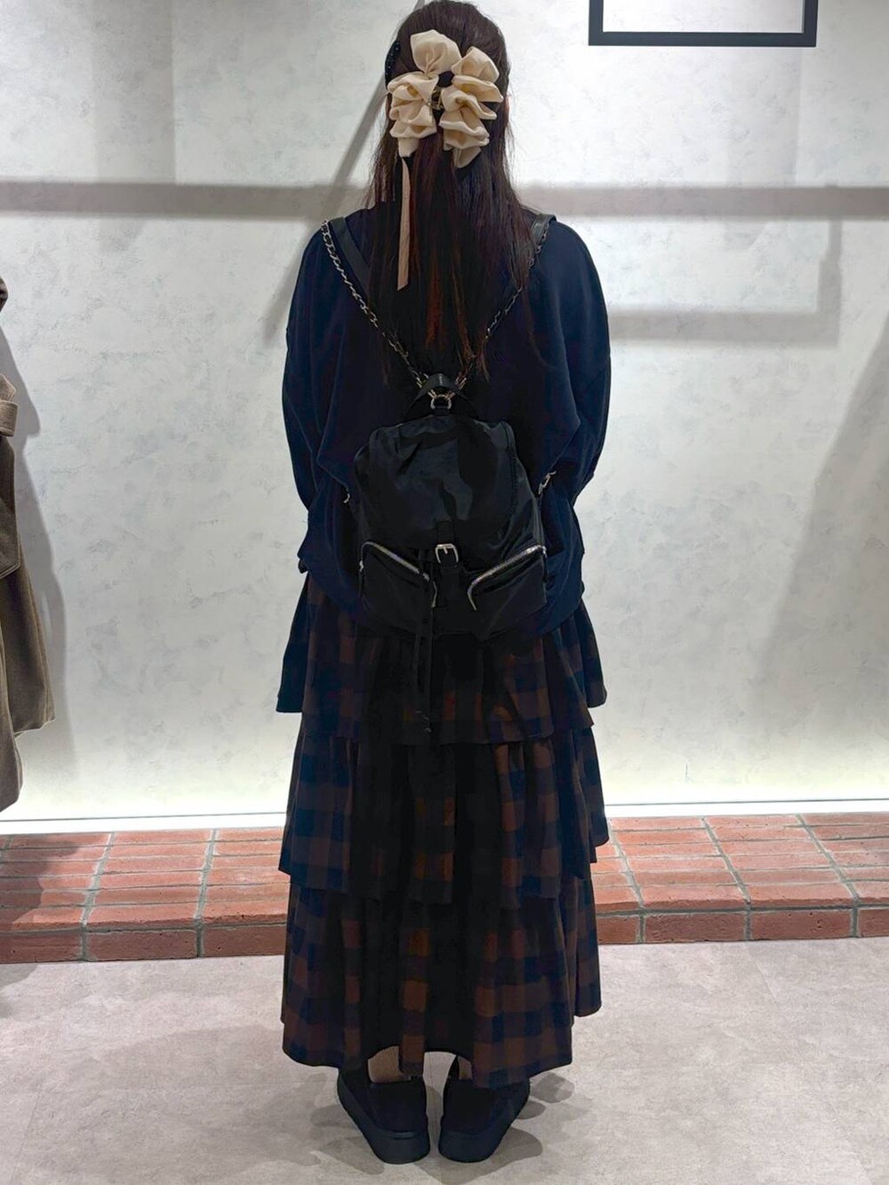 ブラック系のその他シューズ、ブラウン系のスカート、ブラック系のショルダーバッグを着用したレディースの冬コーディネートの3枚目の写真