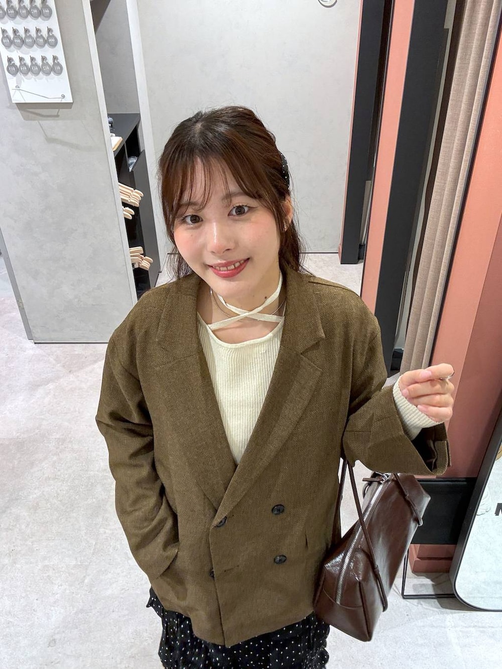 ベージュ系のテーラードジャケット、ベージュ系のニット/セーターを着用したレディースの冬コーディネートの4枚目の写真