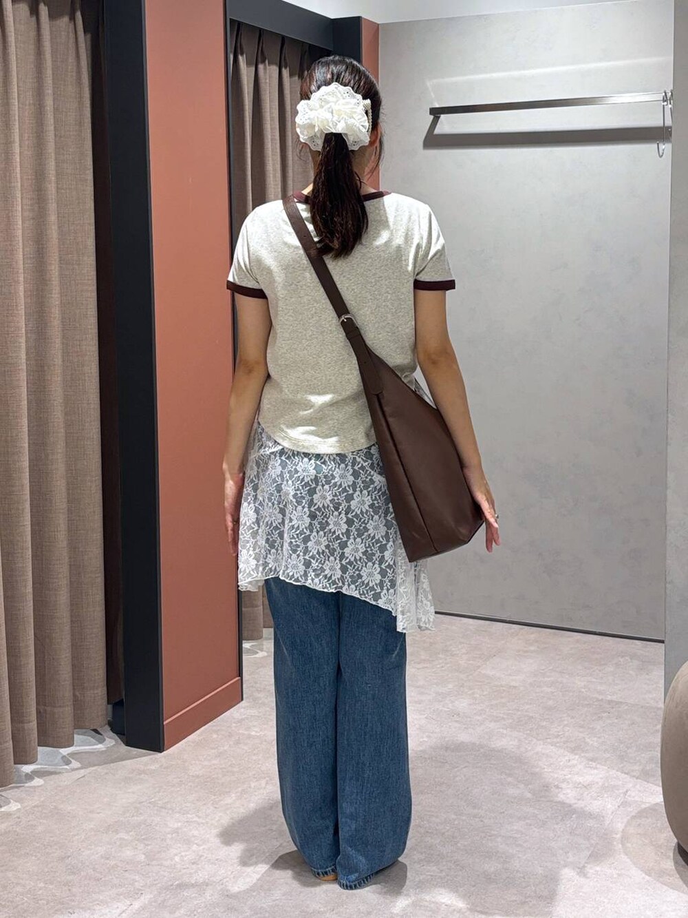 ブラウン系のショルダーバッグ、グレー系のTシャツ/カットソー、ブルー系のデニムパンツを着用したレディースの夏コーディネートの3枚目の写真