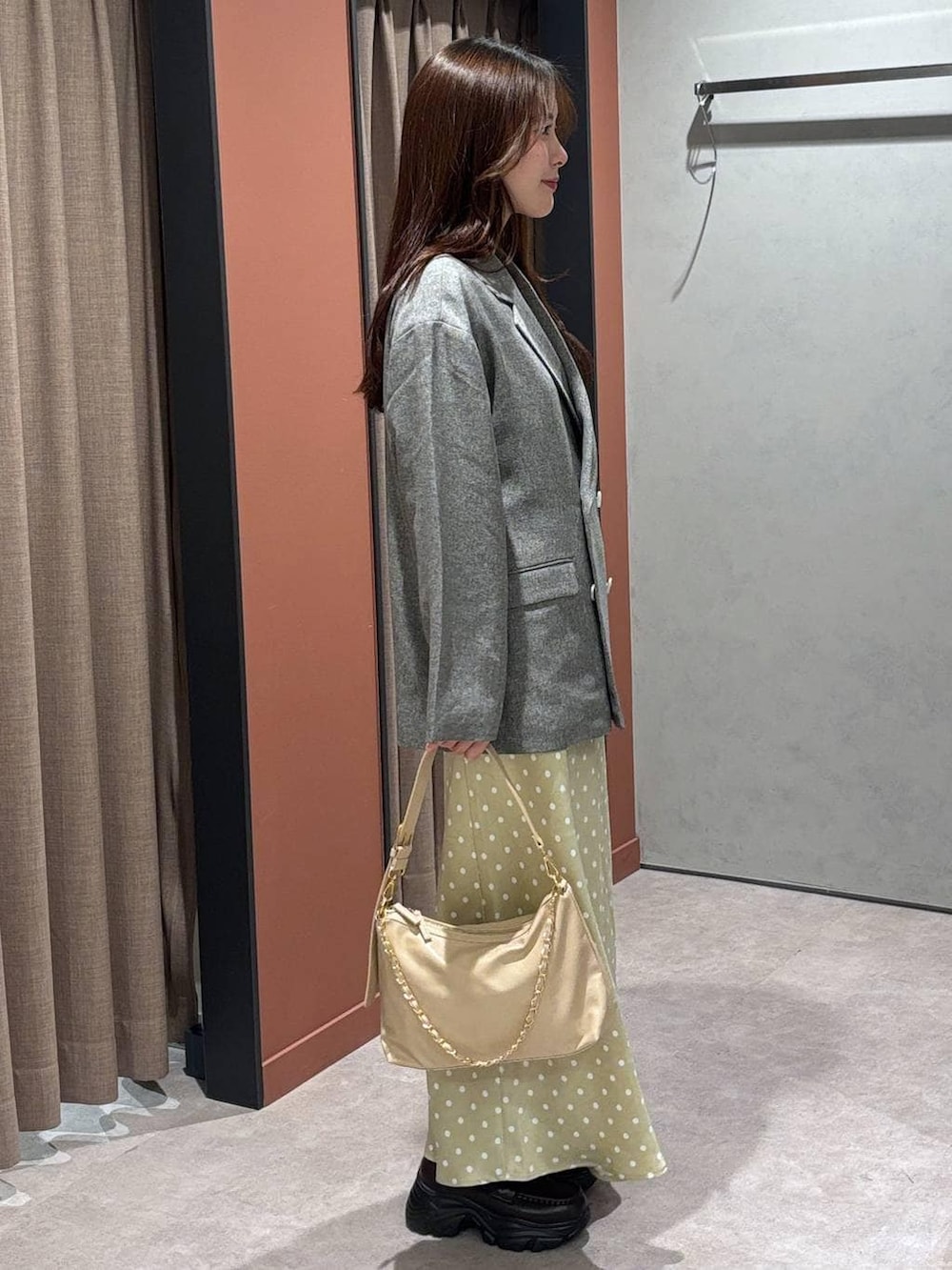 ベージュ系のスカート、グレー系のテーラードジャケット、ベージュ系のショルダーバッグを着用したレディースの冬コーディネートの2枚目の写真