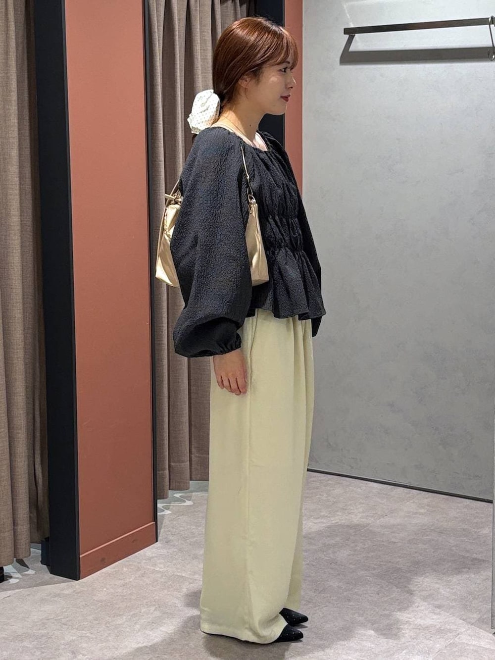 ブラック系のパンプス、ベージュ系のショルダーバッグ、イエロー系のその他パンツを着用したレディースの春コーディネートの2枚目の写真