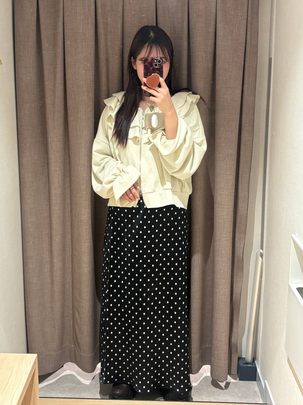 ブラック系のスカート、ブラウン系のローファー、ホワイト系のスウェットを着用したレディースの冬コーディネートの3枚目の写真