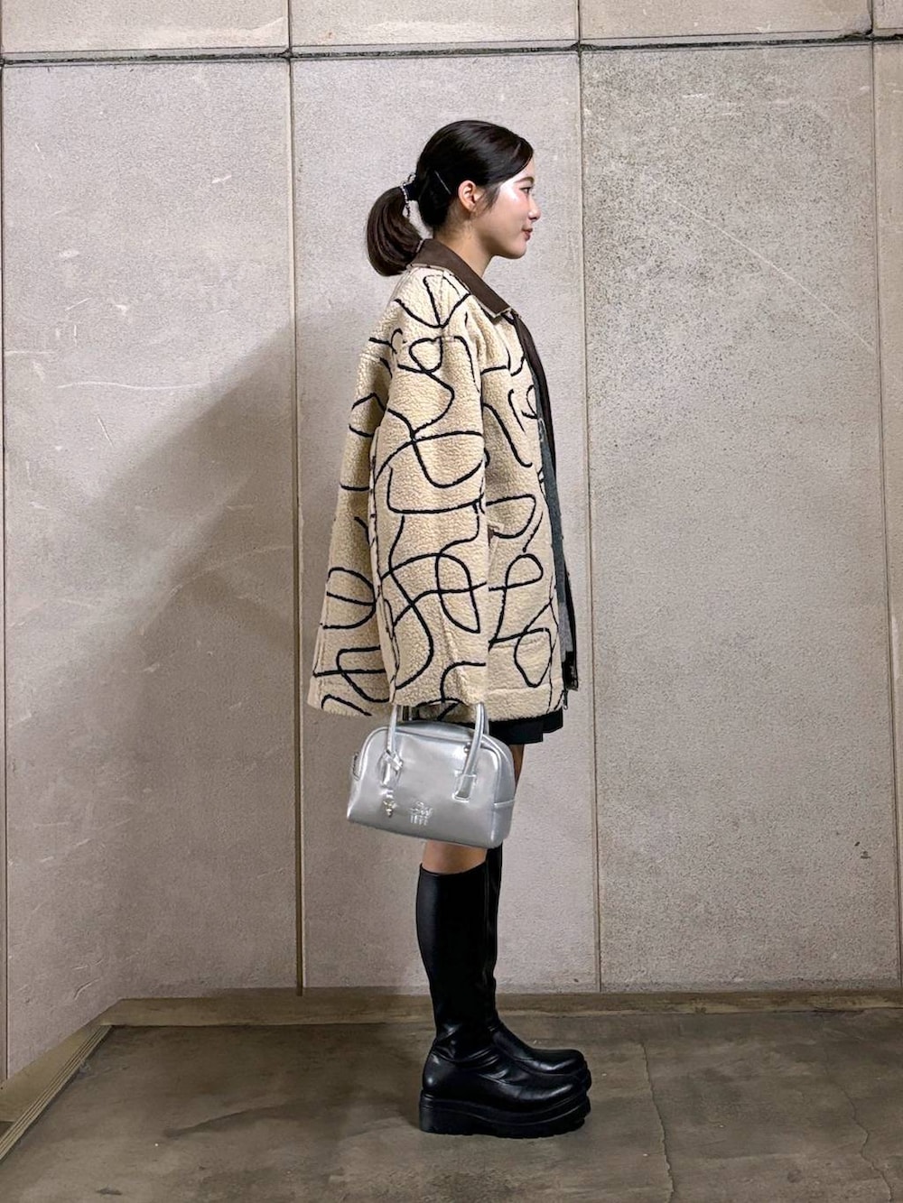 ブラウン系のブルゾン、ブラック系のブーツ、ブラック系のその他パンツを着用したレディースの秋コーディネートの3枚目の写真