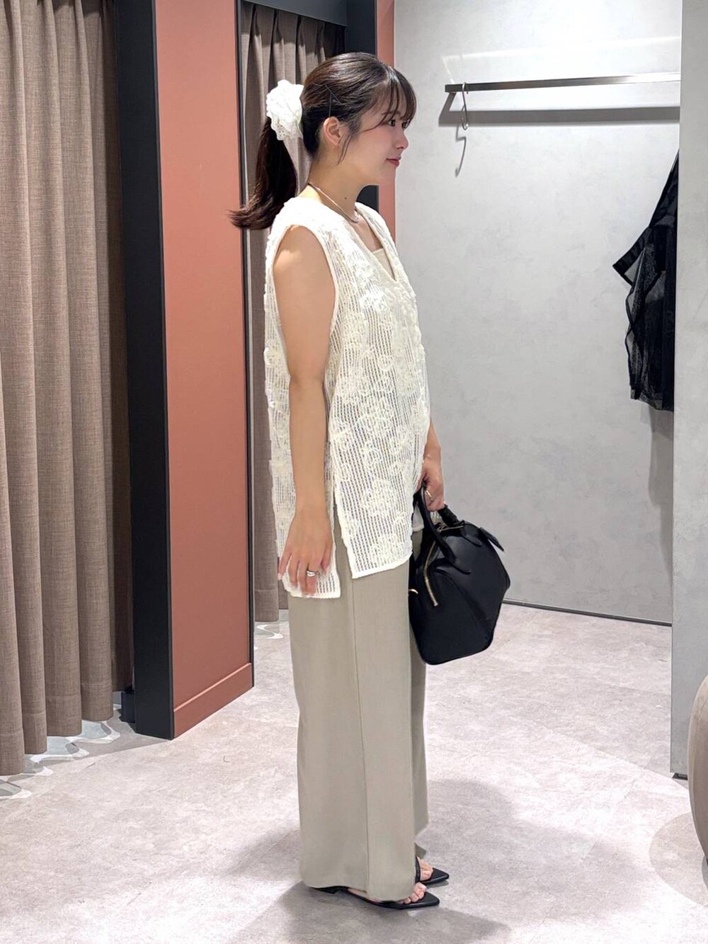 ブラック系のサンダル、ベージュ系のその他パンツ、シルバー系のタンクトップを着用したレディースの夏コーディネートの2枚目の写真